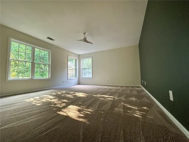 a view of an empty room with window and a fireplace