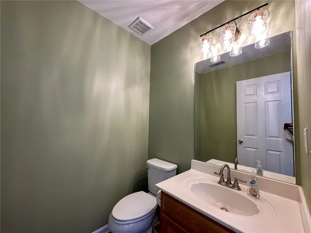 a bathroom with a sink a toilet and mirror