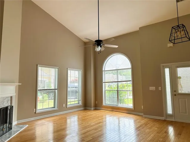 a view of a big room with wooden floor windows and a fireplace