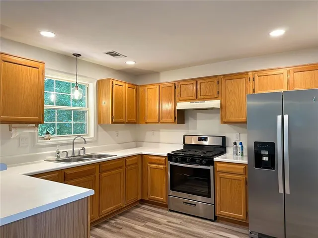 a kitchen with a sink stove and refrigerator