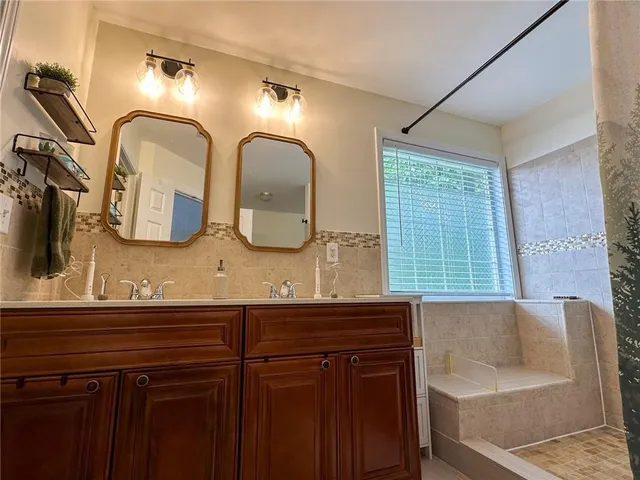a bathroom with a double vanity sink and a mirror