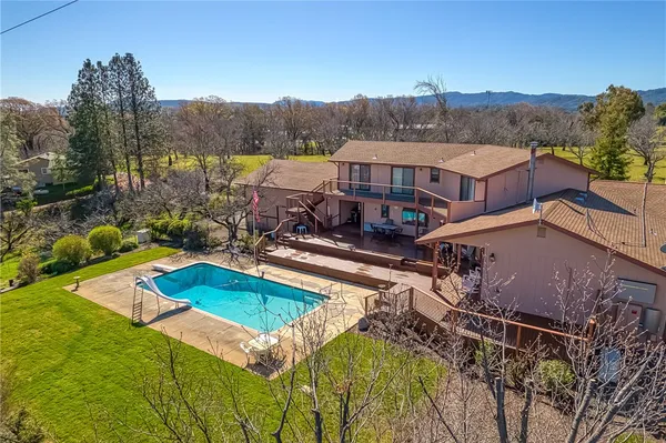 a view of a house with pool and a yard