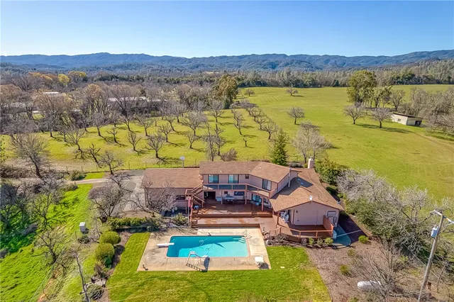 an aerial view of residential houses with outdoor space and swimming pool