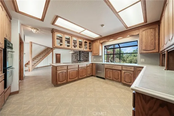 a spacious bathroom with a granite countertop sink a toilet a mirror and window