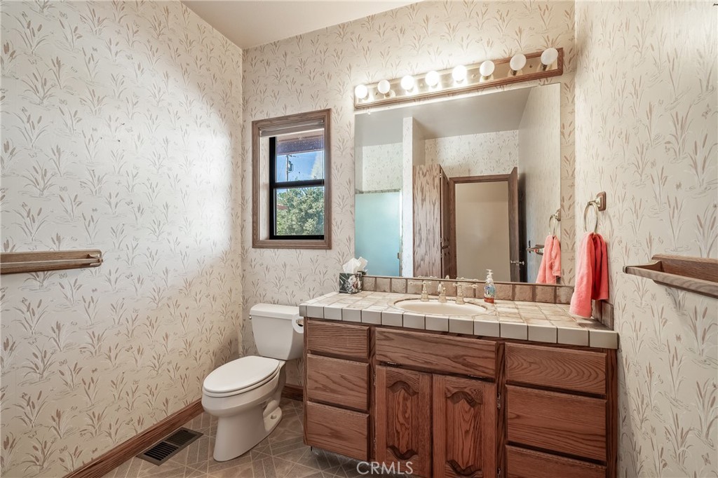 6535 Highland Springs Road Lakeport, CA 95453 - Photo 54 of 75 a bathroom with a double vanity sink toilet and mirror