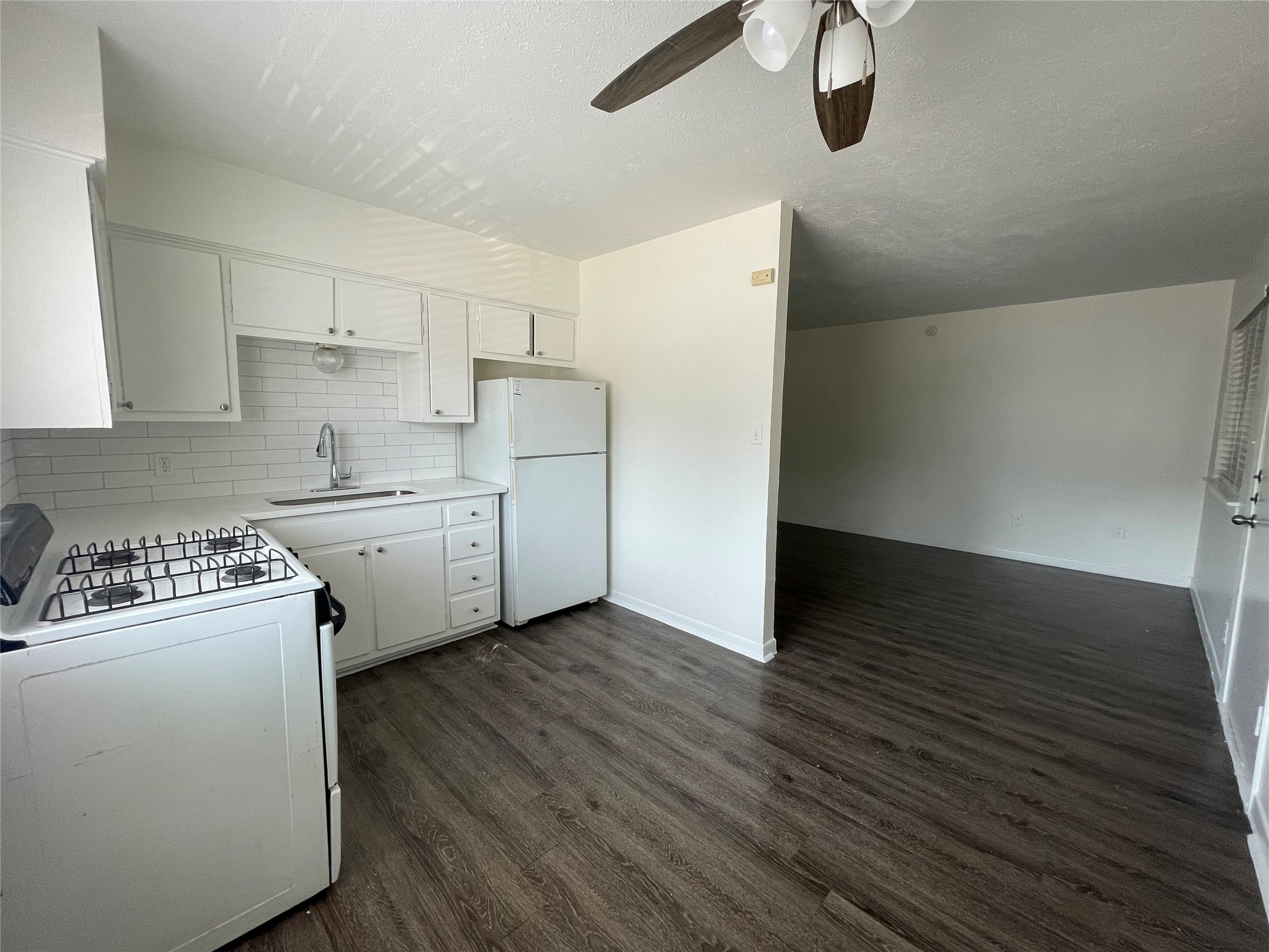 3106 Duval Street, Unit 303 Austin, TX 78705 - Photo 3 of 13 a kitchen with cabinets a sink and white appliances