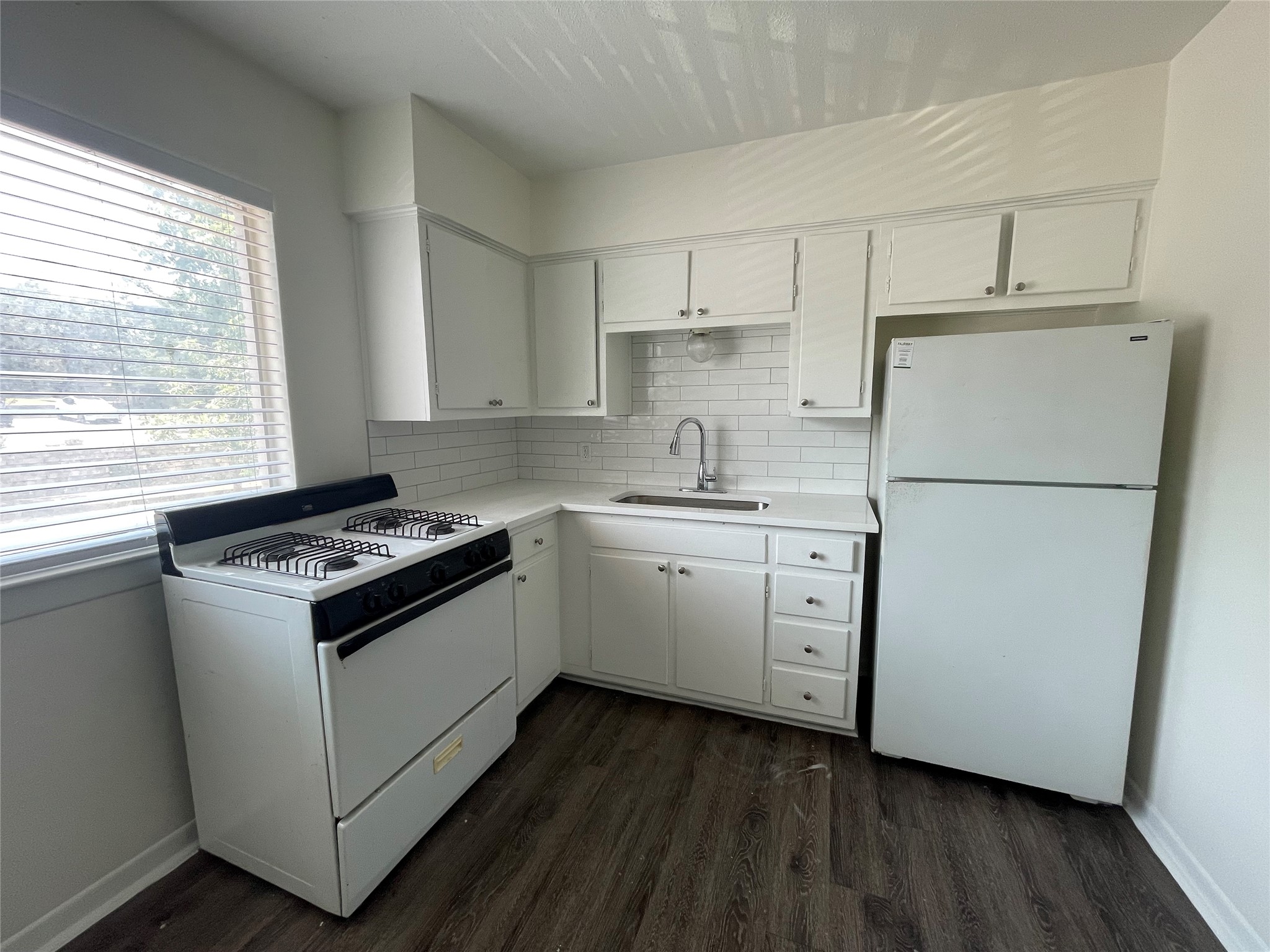 3106 Duval Street, Unit 303 Austin, TX 78705 - Photo 4 of 13 a kitchen with white cabinets appliances a sink and a window