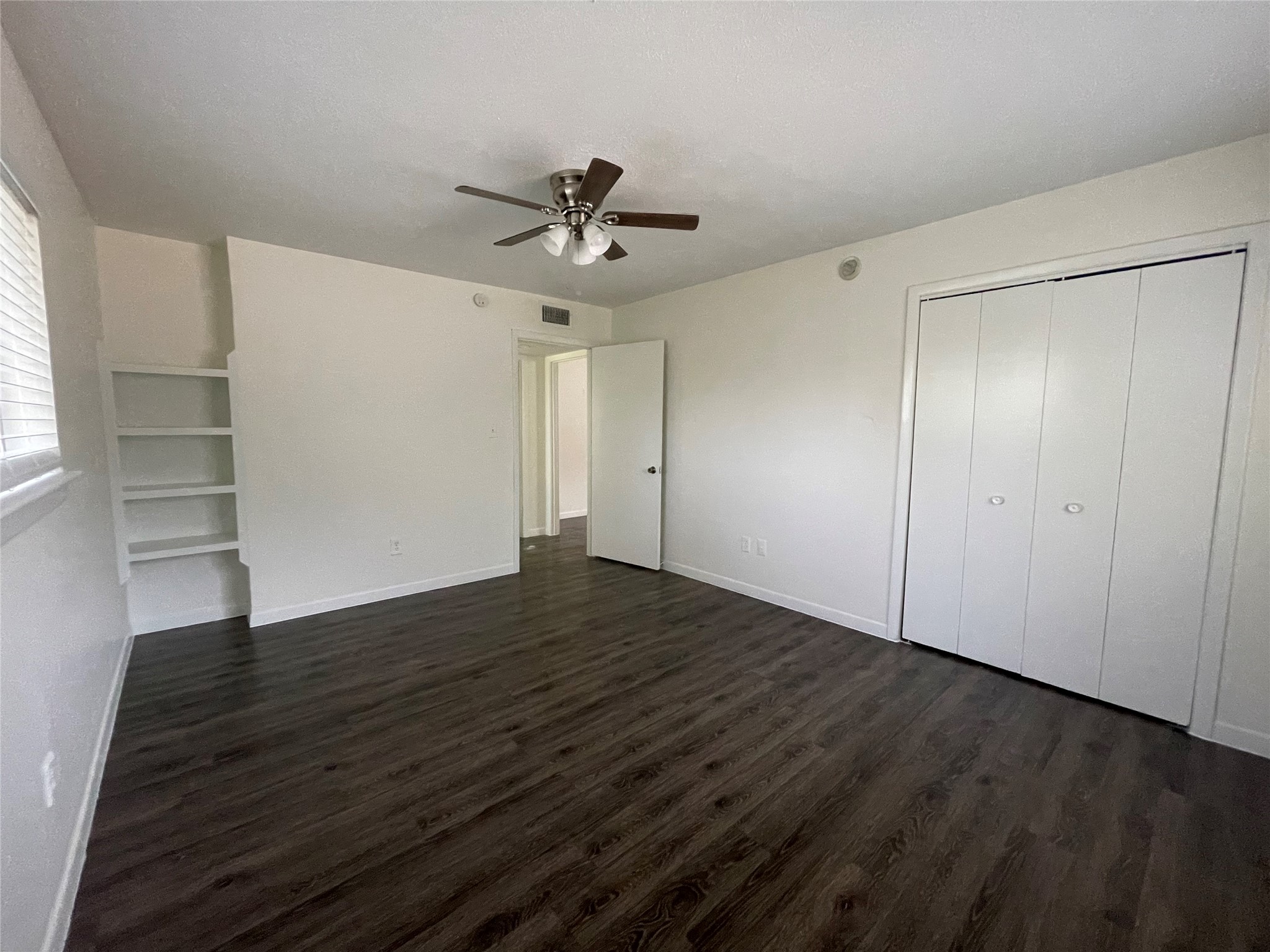 3106 Duval Street, Unit 303 Austin, TX 78705 - Photo 6 of 13 an empty room with wooden floor closet and windows
