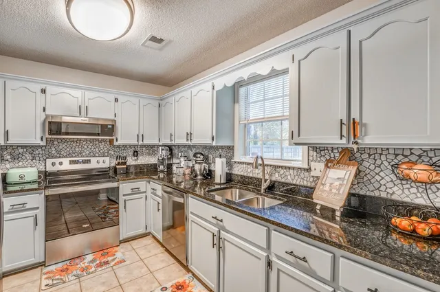 a kitchen with stainless steel appliances granite countertop a sink and cabinets