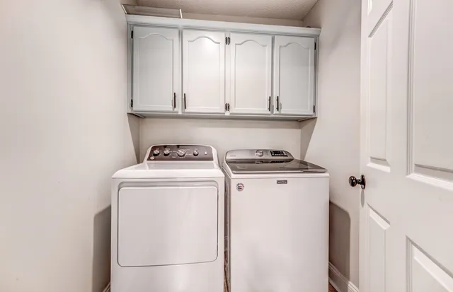 a spacious bedroom with a bed and a flat tv screen on dresser