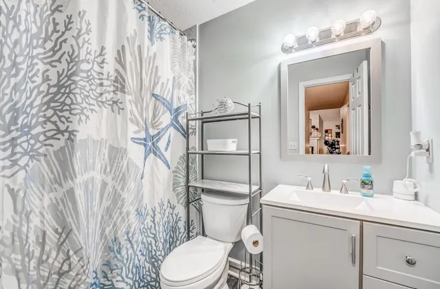 a bedroom with a bed and a lamp on the dresser