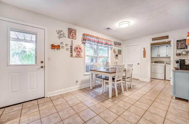 a dining room with stainless steel appliances a table and chairs in it