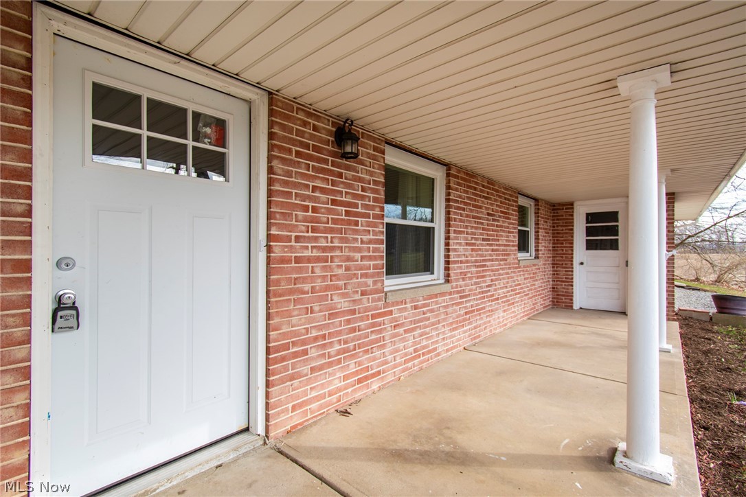 View of exterior entry featuring covered porch