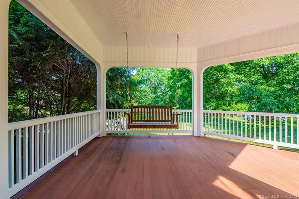 a view of a deck with a floor to ceiling window and wooden fence