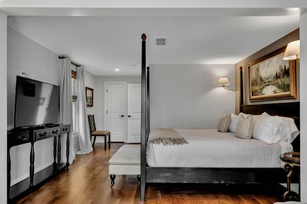 a bedroom with a bed and a flat tv screen on the dresser
