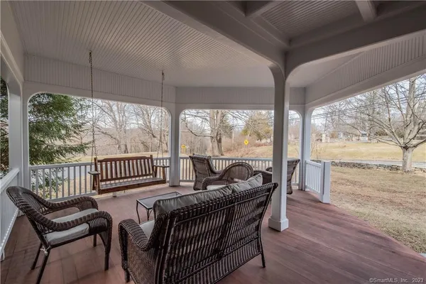 a view of a porch with furniture and wooden floor