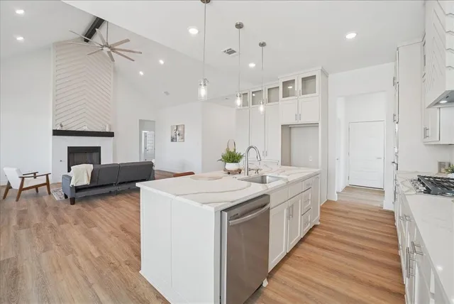 a large kitchen with stainless steel appliances a lot of counter space and a wooden floor