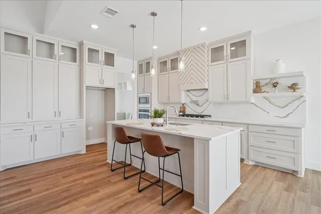 a kitchen with a sink cabinets and wooden floor