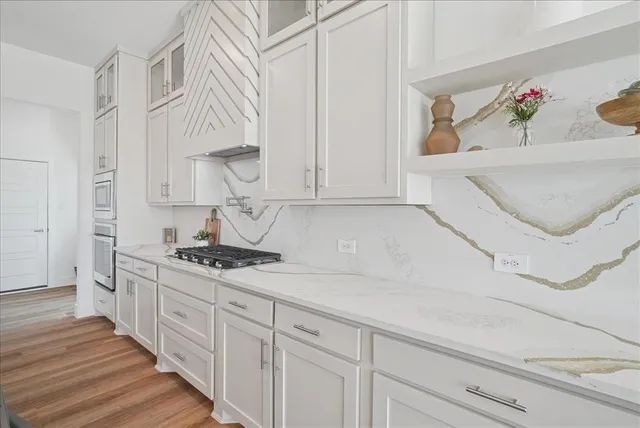 a kitchen with stainless steel appliances granite countertop a sink and cabinets