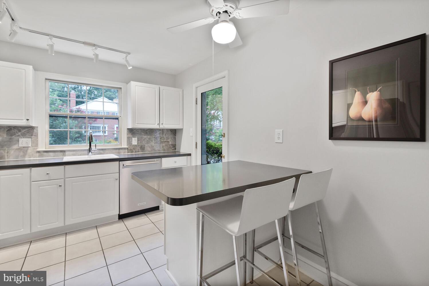 7721 Maryknoll Avenue Bethesda, MD 20817 - Photo 12 of 33 a kitchen with granite countertop a table chairs cabinets and window