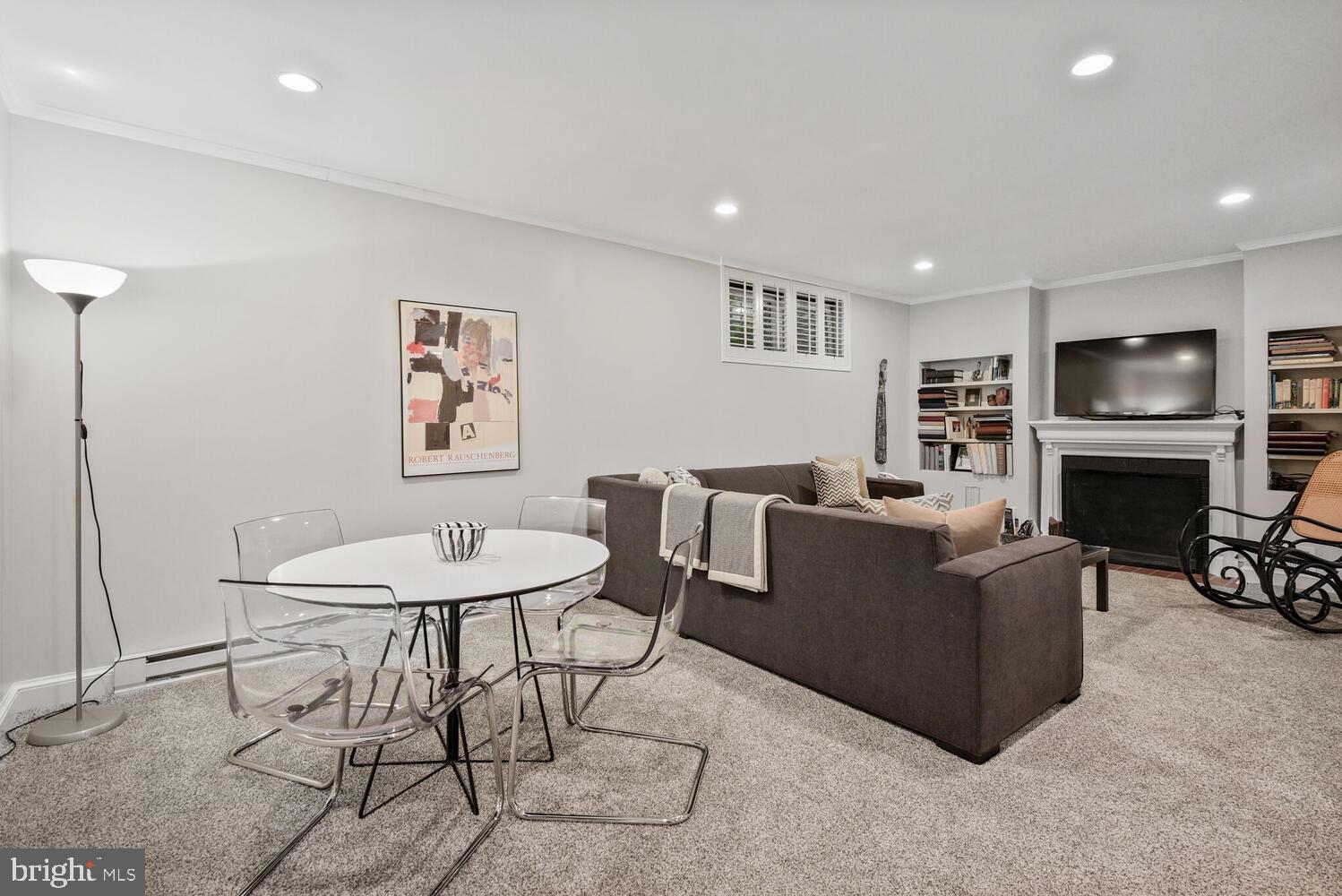 7721 Maryknoll Avenue Bethesda, MD 20817 - Photo 25 of 33 a living room with furniture a fireplace and kitchen view