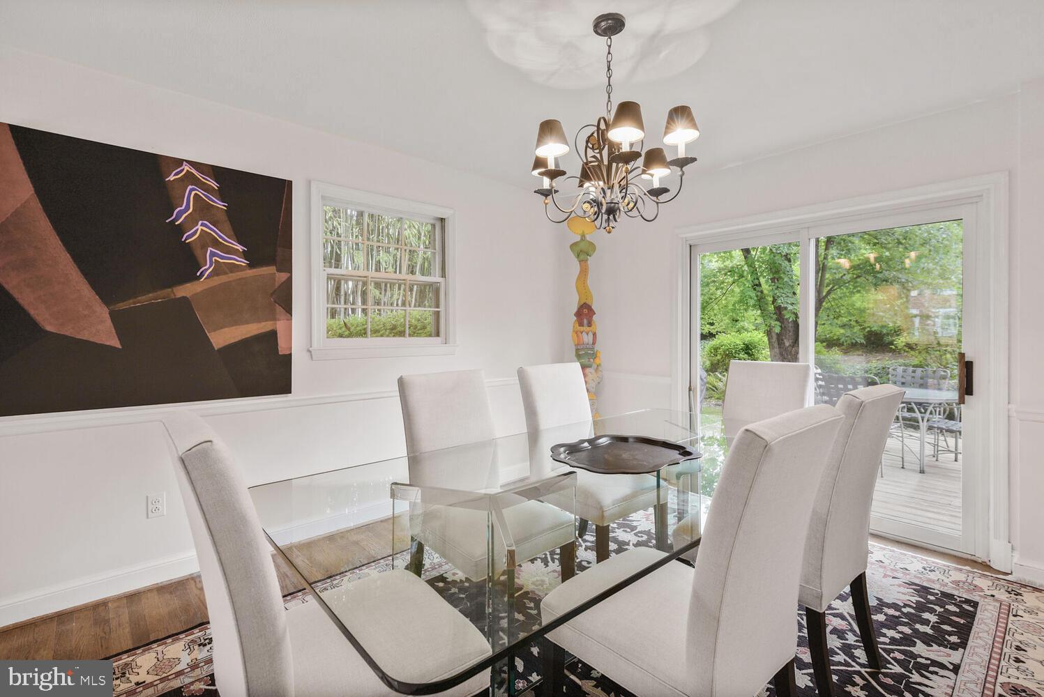 7721 Maryknoll Avenue Bethesda, MD 20817 - Photo 9 of 33 a dining room with furniture a large window and a chandelier