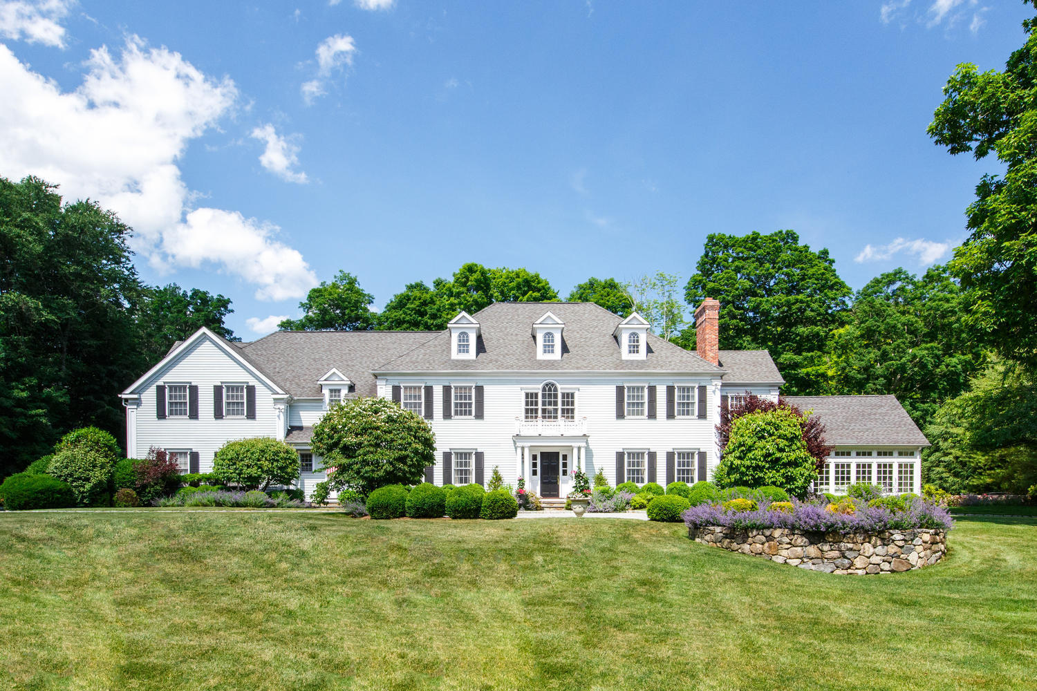 881 Valley Road New Canaan, CT 06840 - Photo 1 of 37 a front view of a house with a yard