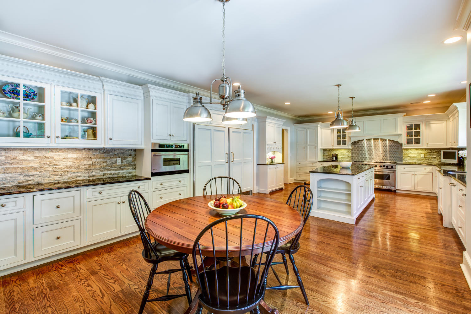 881 Valley Road New Canaan, CT 06840 - Photo 9 of 37 a kitchen with stainless steel appliances granite countertop a kitchen island a stove a table and chairs