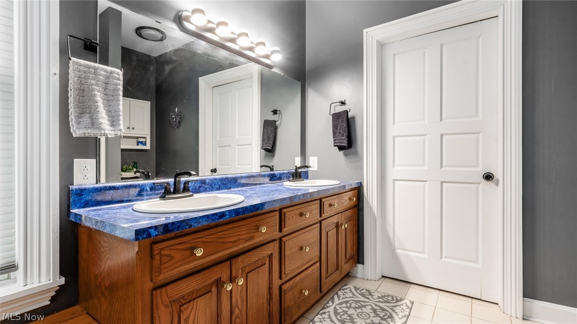 2531 Nicholas Lane Dresden, OH 43821 - Photo 15 of 40 Double vanity with a blue countertop, dual undermount sinks, and dark fixtures