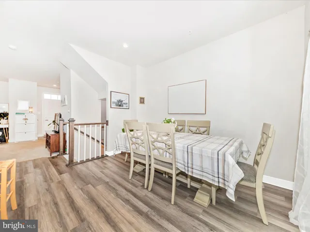 a large white room with kitchen island a flat screen tv and a refrigerator