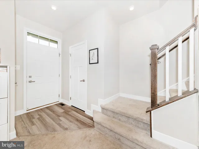 a view of a livingroom with wooden floor and staircase