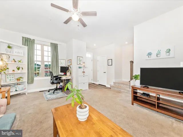 a view of a kitchen with kitchen island stainless steel appliances wooden floor and living room view