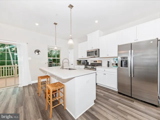 a kitchen with granite countertop cabinets stainless steel appliances and wooden floor