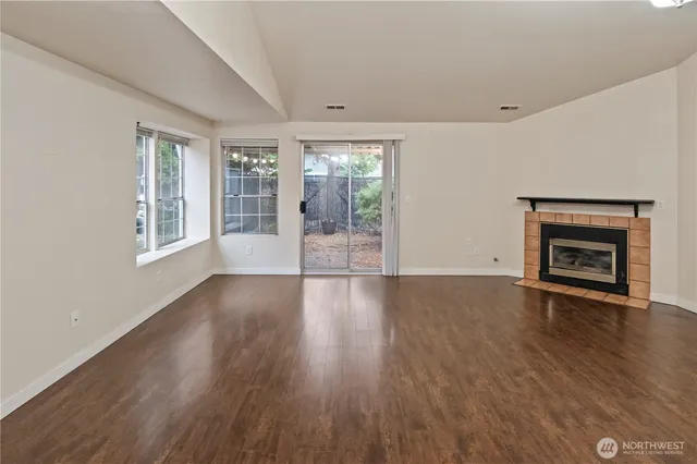 an empty room with wooden floor and fireplace