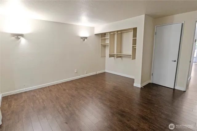 a view of an empty room with wooden floor