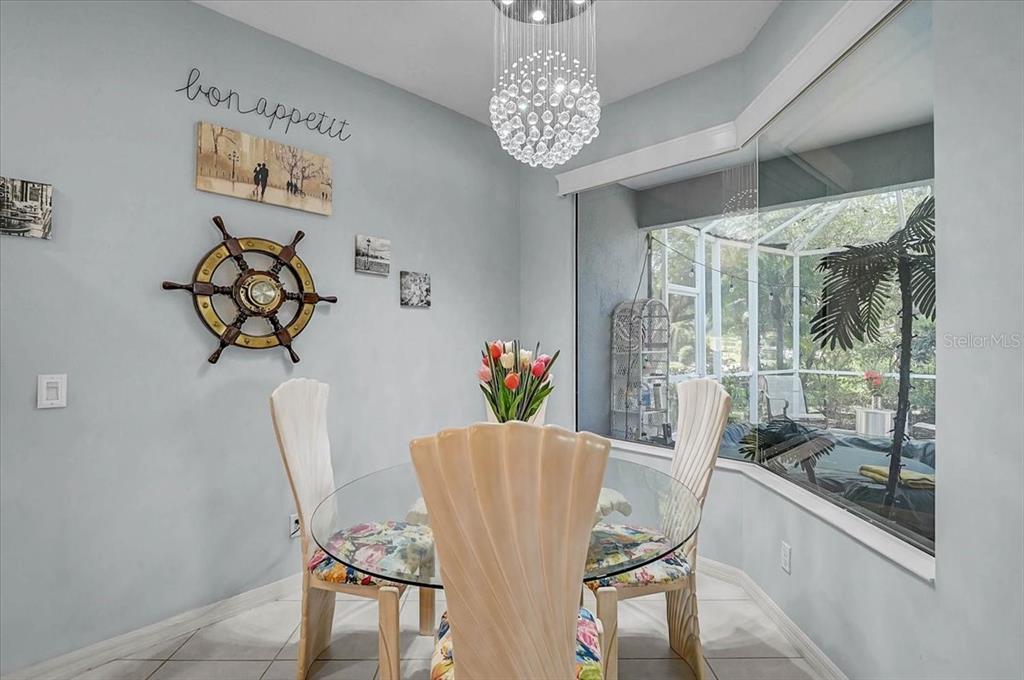 103 Bishopscourt Road Osprey, FL 34229 - Photo 14 of 55 a view of a dining room with furniture a chandelier and wooden floor