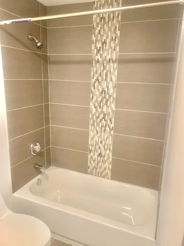 a bathroom with toilet shower and bathtub