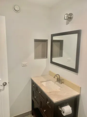 a bathroom with a granite countertop sink a mirror and vanity