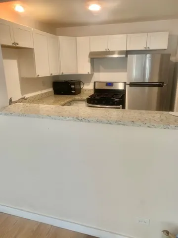 a kitchen with a stove and white cabinets