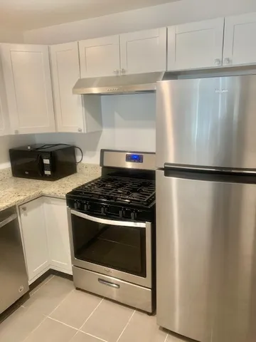a stove top oven sitting inside of a kitchen