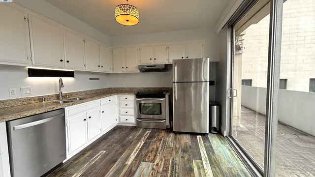 a kitchen with granite countertop a refrigerator and a sink