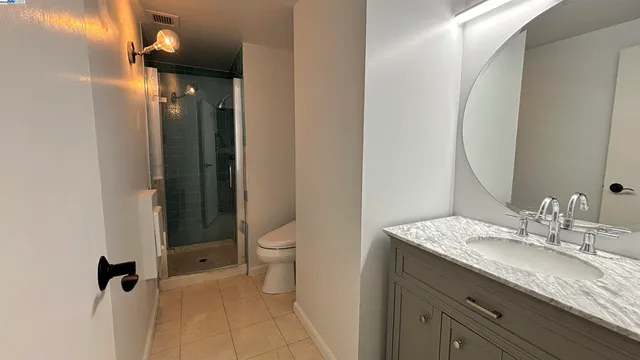 a bathroom with a granite countertop sink toilet and shower