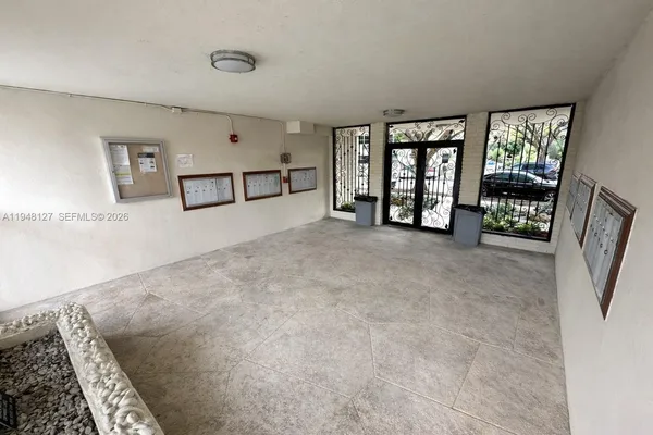 a view of an empty room with window and stairs