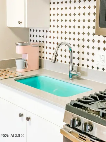 a kitchen with a stove and a white cabinet