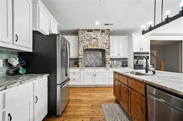 a kitchen with stainless steel appliances granite countertop sink stove and wooden floor