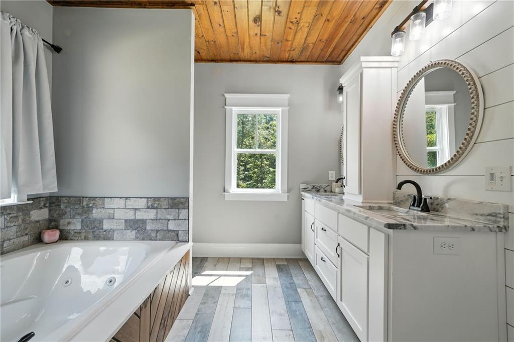 14430 Fincher Road Ball Ground, GA 30107 - Photo 35 of 51 a bathroom with a granite countertop sink mirror vanity and bathtub