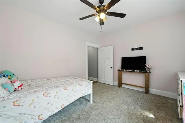 a bedroom with a bed a window and a flat screen television