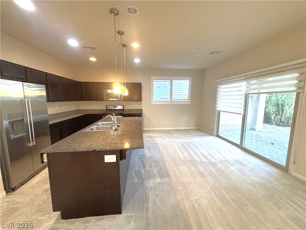 121 Elm Reed Avenue Las Vegas, NV 89113 - Photo 9 of 30 A well-appointed kitchen island with a double sink anchors this open living space, leading to a sun-filled patio.