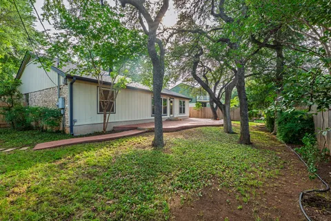 a house is sitting in middle od the grass