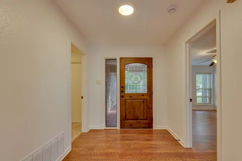 a view of a hallway with wooden floor